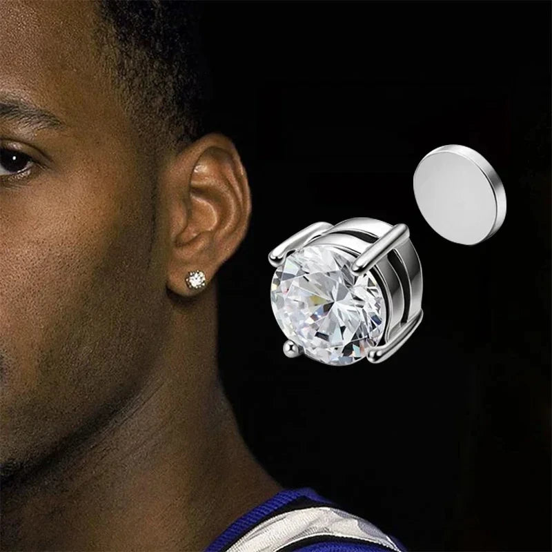 Close-up of a person wearing a silver earring with a large clear gemstone, with another similar earring displayed.