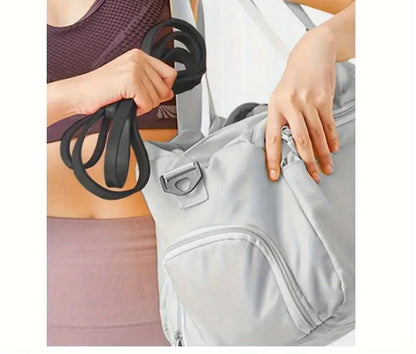Person holding resistance bands and a gray bag