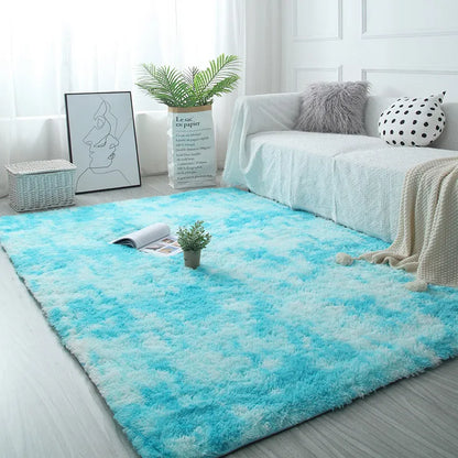 Living room with a blue and white gradient rug, sofa, and decor items.