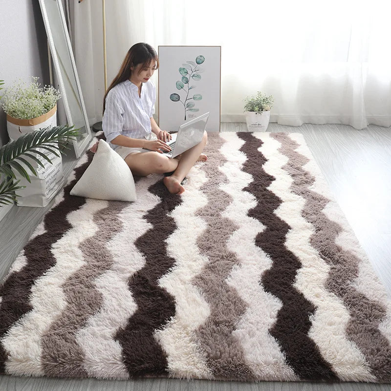 Woman sitting on a patterned rug in a bright room with plants and a mirror.