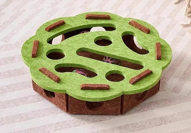 Green and brown puzzle toy for pets on a textured surface