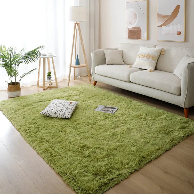 Living room with a green rug, white sofa, and decorative elements.