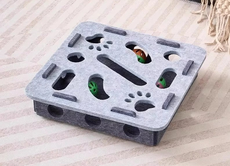 Gray foam block with various holes and cutouts on a light wooden surface