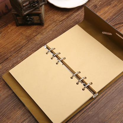 Beige notebook with metal rings on a wooden surface