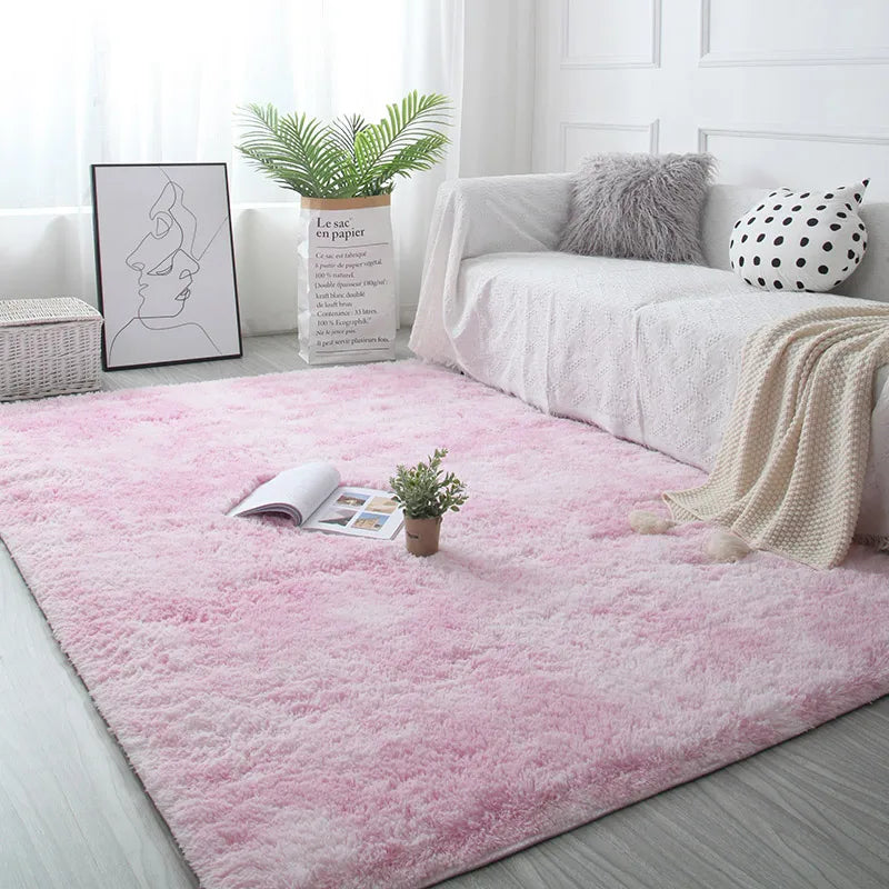 Living room with a pink rug, white sofa, and decorative items.