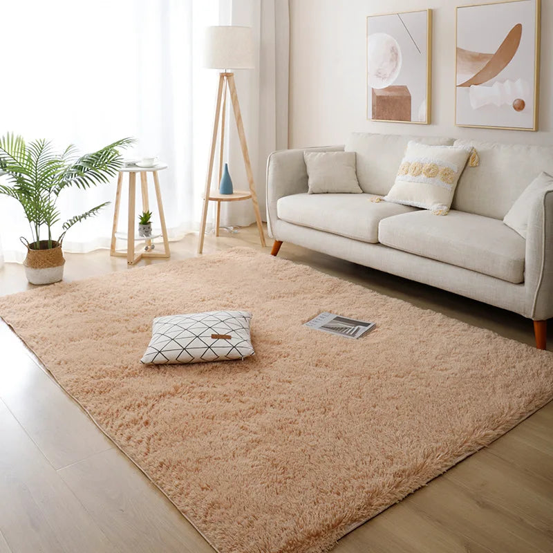 Beige rug in a living room with a white sofa and decorative pillows.