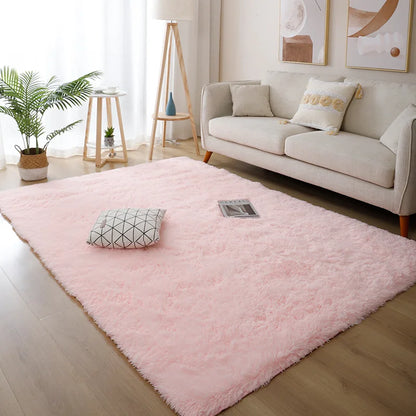 Living room with a pink rug, white sofa, and decorative elements.