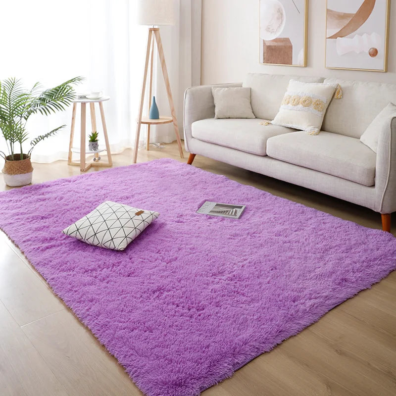 Living room with a purple rug, white sofa, and decorative elements.