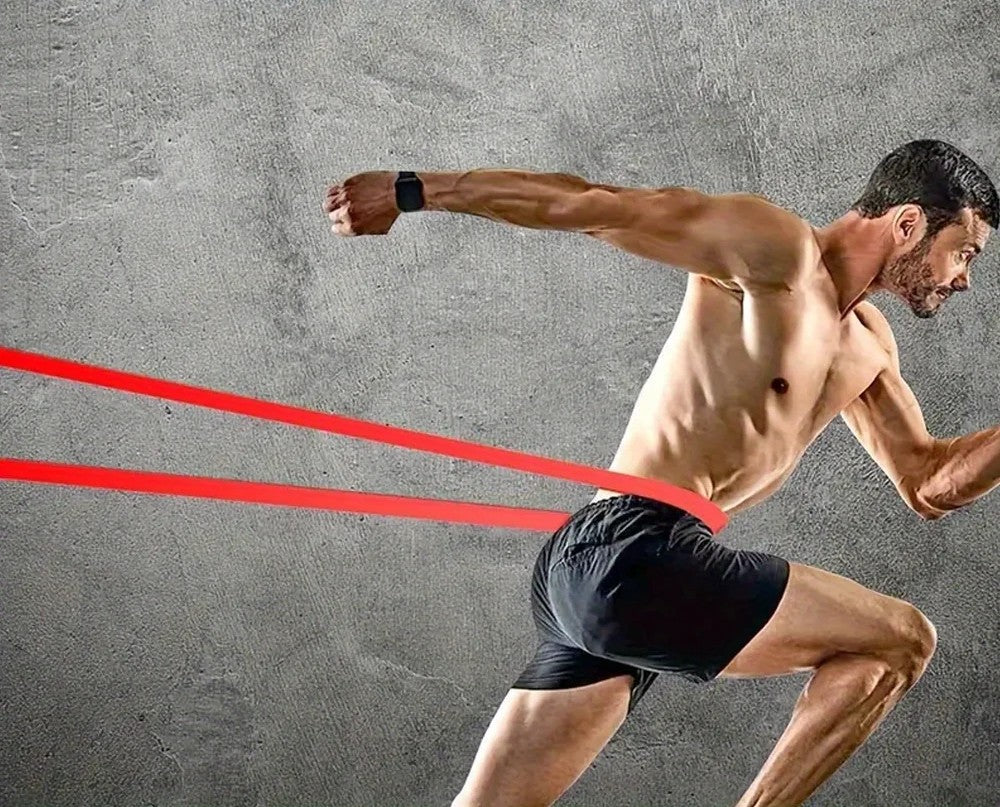 Man running with a resistance band against a gray background